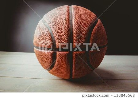 Close-up of basket ball on table against black background Close-up of basket ball on table against black background 133843568