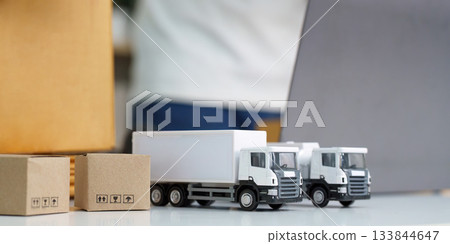 Logistics. Miniature trucks and packages representing the shipping industry and transportation. 133844647