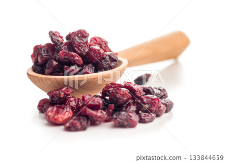 Tasty dried cranberries on wooden spoon isolated on white background. Tasty dried cranberries on wooden spoon isolated on white background. 133844659