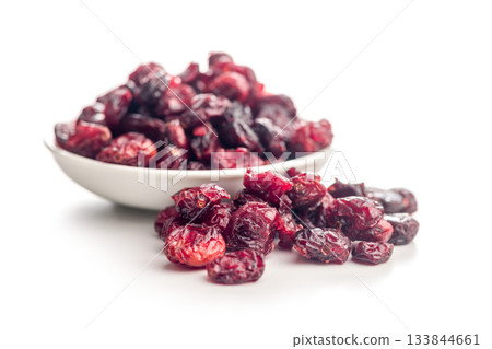 Tasty dried cranberries in bowl isolated on white background. Tasty dried cranberries in bowl isolated on white background. 133844661