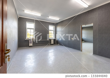 Empty Office Room with Grey Walls and Bright Windows 133844840