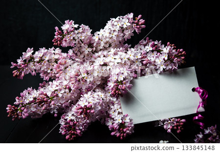 Lilac Blossoms Set Against Dark Planks with a Blank Gift Tag Lilac Blossoms Set Against Dark Planks with a Blank Gift Tag 133845148