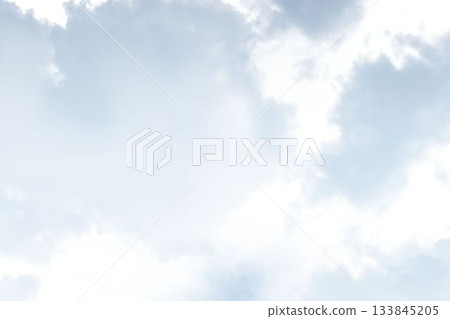 Cumulus clouds are drifting across pale blue sky in flat design showing soft lighting, copy space 133845205