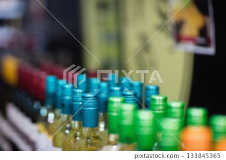 Glass bottles are being displayed in flat design retail shelf scene, with colored screw-top caps Glass bottles are being displayed in flat design retail shelf scene, with colored screw-top caps 133845365