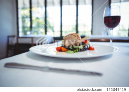 Lamb chop and wineglass on table 133845419