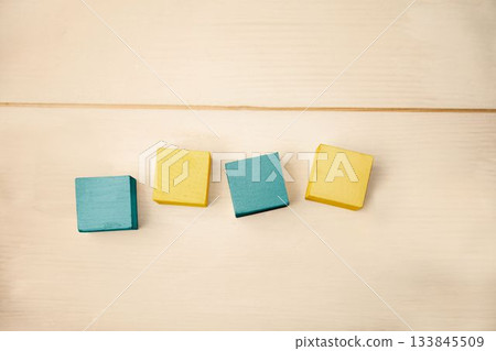 Flat design is showing four wooden blocks in row on wood surface, highlighting teal and yellow 133845509
