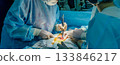 A surgeon's hands, wearing sterile gloves, are holding an electrocautery device 133846217