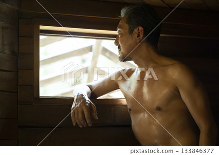 一名 50 多歲的男子正在享受桑拿 133846377