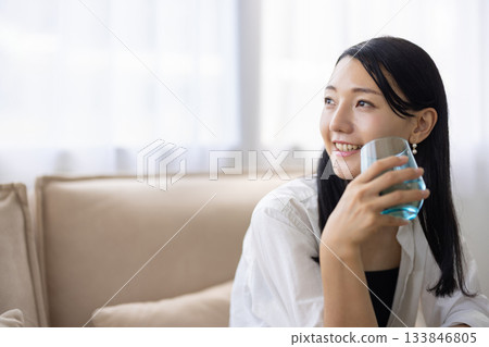 一位微笑的女子手捧一杯水 133846805