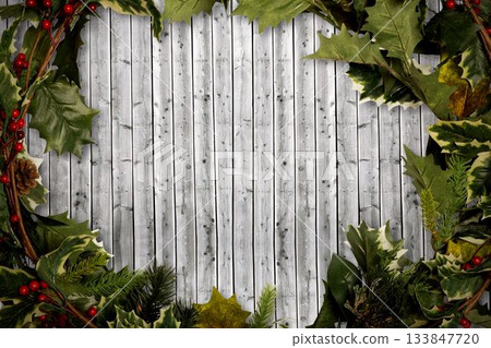 Holly twigs over wooden planks Holly twigs over wooden planks 133847720