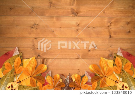 Rustic flat design is showing wooden plank surface with fallen autumn leaves border, copy space 133848010