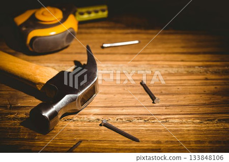 Flat design showing claw hammer lying on workbench, scattered nails, tape measure, bubble level Flat design showing claw hammer lying on workbench, scattered nails, tape measure, bubble level 133848106