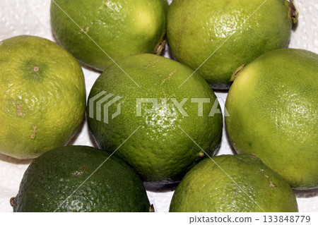 Close up of fresh green lime fruits on white background Close up of fresh green lime fruits on white background 133848779