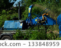 An operator loads tree branches into a wood chipper. 133848959