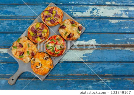 Pizzas arranged on wooden table 133849167
