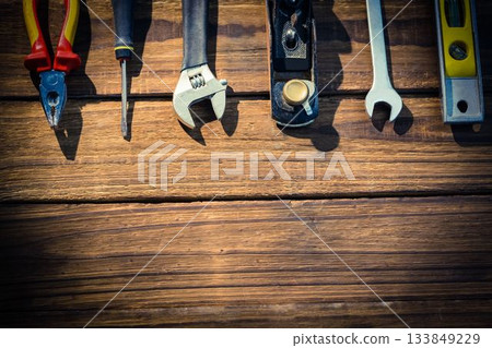 Flat design is showing hand tools on wood plank, featuring pliers screwdriver wrench plane level Flat design is showing hand tools on wood plank, featuring pliers screwdriver wrench plane level 133849229