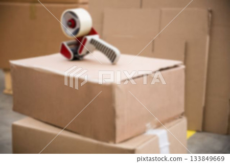 Tape Dispenser on stacked cardboard box in warehouse 133849669