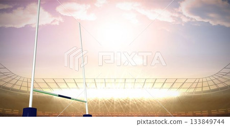 Rugby goalposts are standing on pitch in flat stadium with floodlights under sunset-lit curved roof Rugby goalposts are standing on pitch in flat stadium with floodlights under sunset-lit curved roof 133849744
