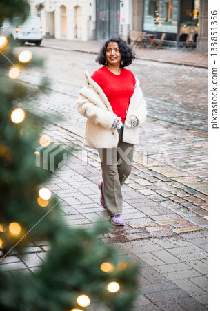 indian woman walking on festive street with christmas lights in helsinki 133851356