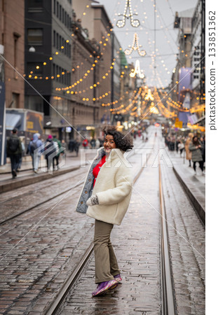 indian woman walking on festive street with christmas lights in helsinki 133851362