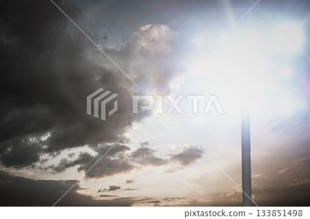 Metal lamp post with glowing fixture is radiating lens flares in flat design under dramatic clouds Metal lamp post with glowing fixture is radiating lens flares in flat design under dramatic clouds 133851498
