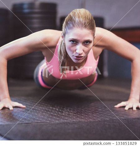 Young woman doing push ups at gym 133851829