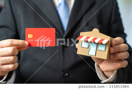 A businessman runs a store and a credit card. A bank debit card. Cashless purchases, the introduction of self-service terminals. Fintech trends, retail modernization and consumer payment behavior. 133851964