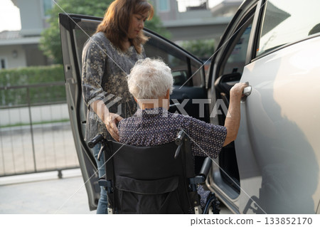 Caregiver help Asian elderly woman disability patient get in her car. Caregiver help Asian elderly woman disability patient get in her car. 133852170