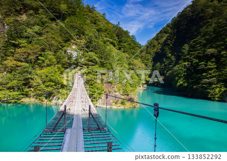 The dream suspension bridge spanning the surface of the Emerald Green lake The dream suspension bridge spanning the surface of the Emerald Green lake 133852292