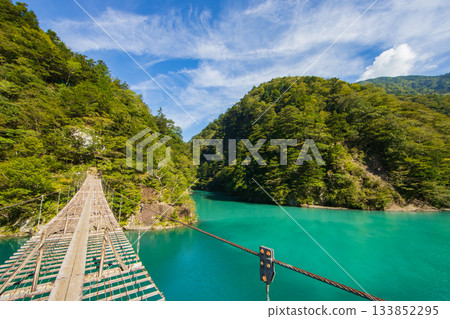 The dream suspension bridge spanning the surface of the Emerald Green lake The dream suspension bridge spanning the surface of the Emerald Green lake 133852295