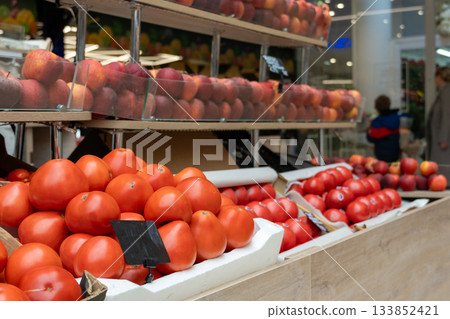 A vibrant display of fresh, ripe red tomatoes and nectarines 133852421