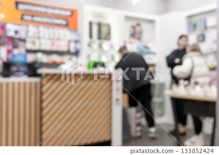 A busy, blurred interior of a modern retail shop with customers A busy, blurred interior of a modern retail shop with customers 133852424