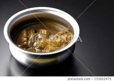 盛在銀盤中的咖哩雞，以黑色背景拍攝。 133852473