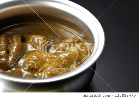 盛在銀盤中的咖哩雞，以黑色背景拍攝。 133852479