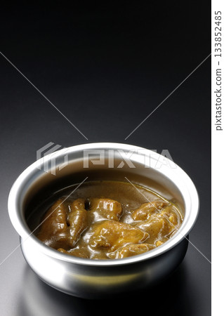 盛在銀盤中的咖哩雞，以黑色背景拍攝。 133852485