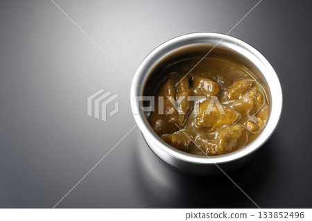 Chicken curry served in silver dish photographed against a black background Chicken curry served in silver dish photographed against a black background 133852496