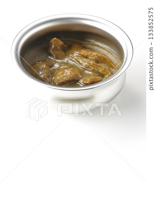 Chicken curry served in silver dish photographed against a white background 133852575