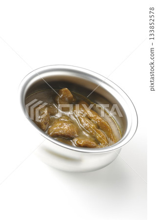 Chicken curry served in silver dish photographed against a white background Chicken curry served in silver dish photographed against a white background 133852578