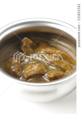 Chicken curry served in silver dish photographed against a white background Chicken curry served in silver dish photographed against a white background 133852581
