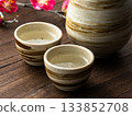 Japanese-style table image with ceramic sake cups and plum blossoms 133852708