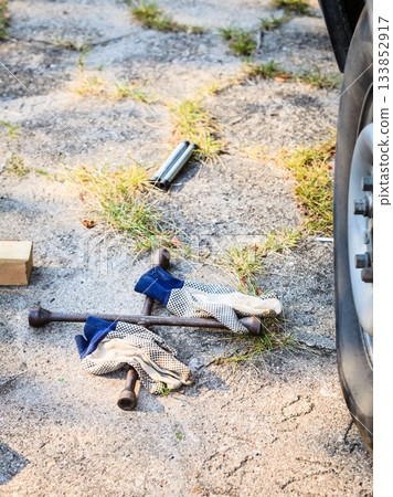Socket wheel wrench and jack lying on ground 133852917