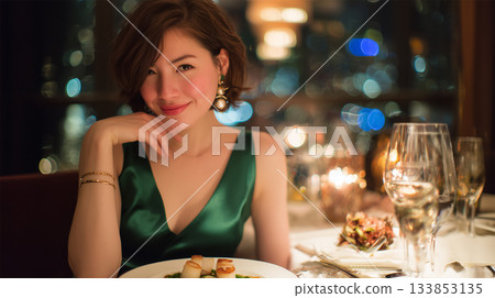一位身穿綠色洋裝的女士正在用餐。 一位身穿綠色洋裝的女士正在用餐。 133853135