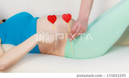 Couple expecting baby, playing with heart sticks Couple expecting baby, playing with heart sticks 133853205