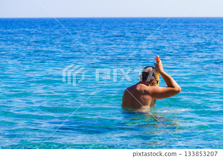 Man with snorkeling tube in sea 133853207