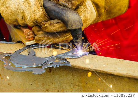 Man making art using metal cutter. Man making art using metal cutter. 133853227
