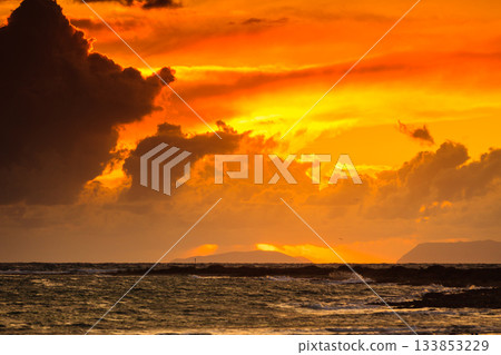 Sunset over sea surface, dark clouds. Sunset over sea surface, dark clouds. 133853229
