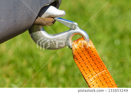 Tow hook with orange strap on car. Towing equipment. Tow hook with orange strap on car. Towing equipment. 133853249