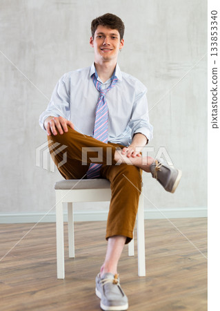 Young guy office worker doing exercises on chair 133853340