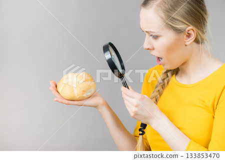Shocked woman magnifying bun bread roll Shocked woman magnifying bun bread roll 133853470