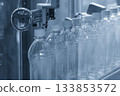 The  empty drinking water bottles  on the  conveyor belt for filling process in the blue scene. 133853572